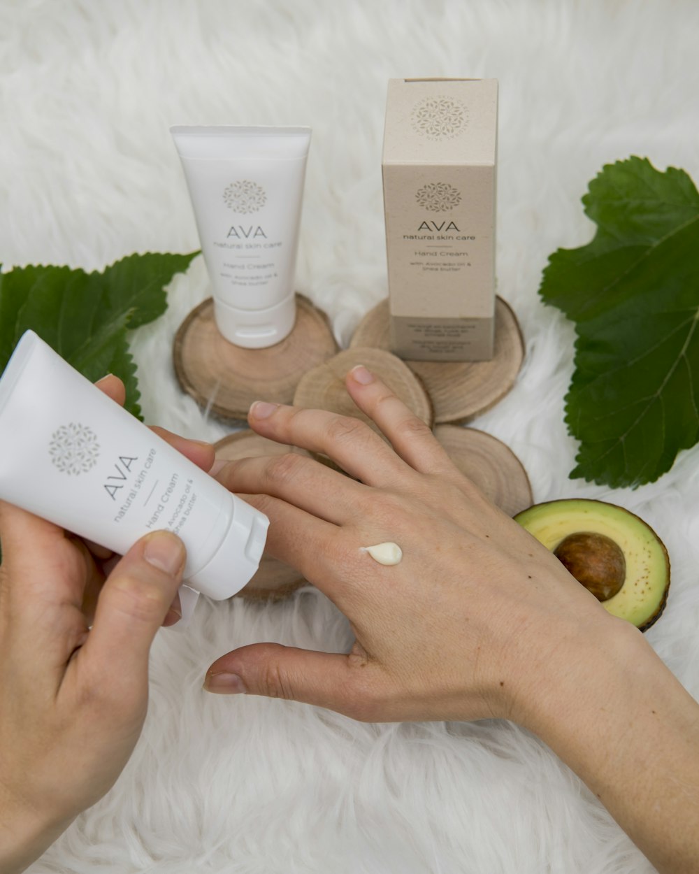 Botanical hand cream and fresh green leaves arranged on linen
