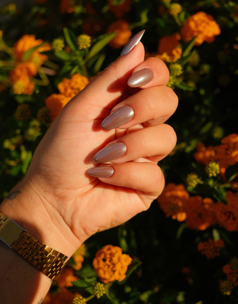 Champagne shimmer nails against a bed of orange marigolds