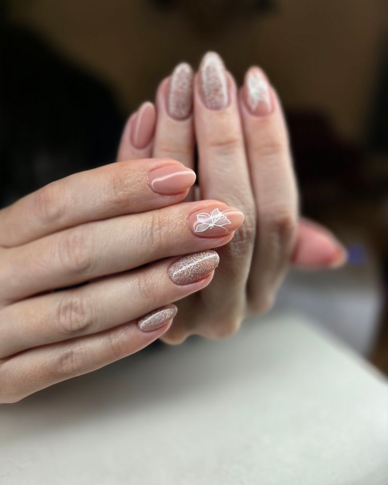 Two hands with a nude and champagne glitter gel overlay
