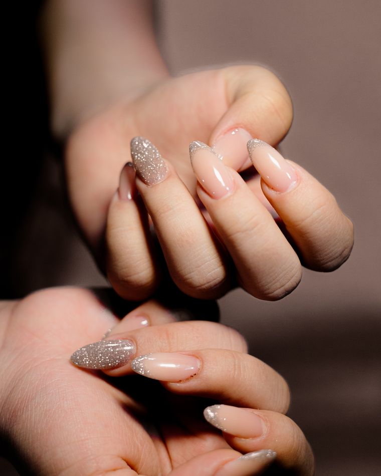 Hands with a warm nude overlay and fine glitter running through it