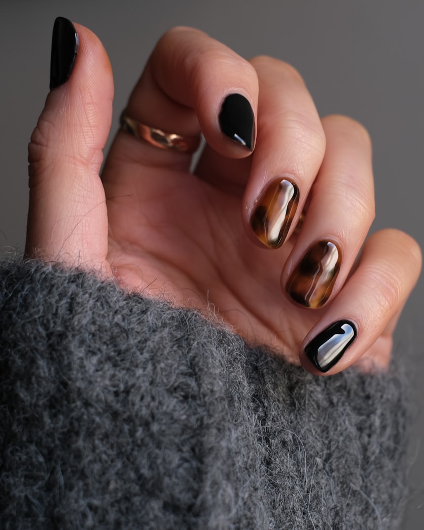 Close-up of a finished manicure in dark polish, shot in black and white