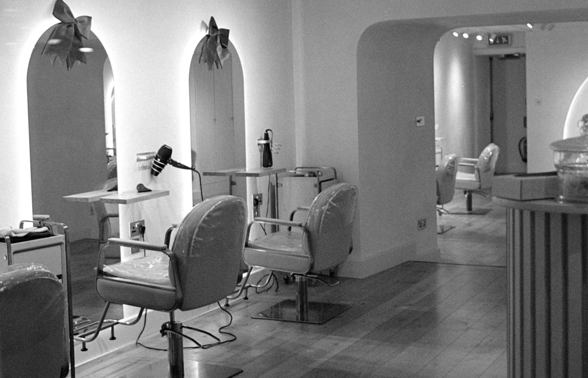 The studio interior — chairs, mirrors and a bench, shot in black and white