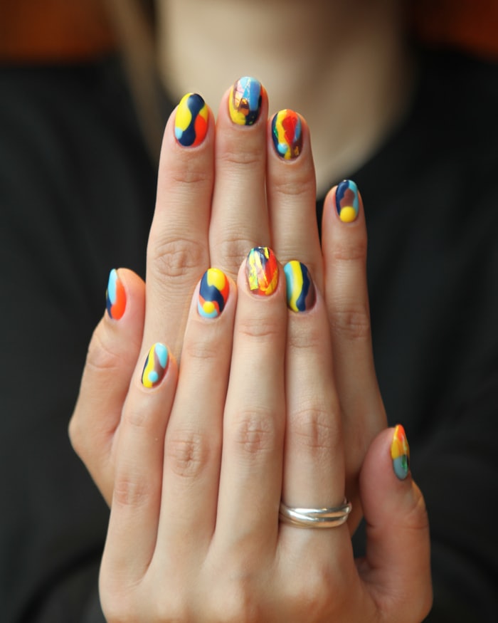 Two hands with sculpted extensions and metallic finishes