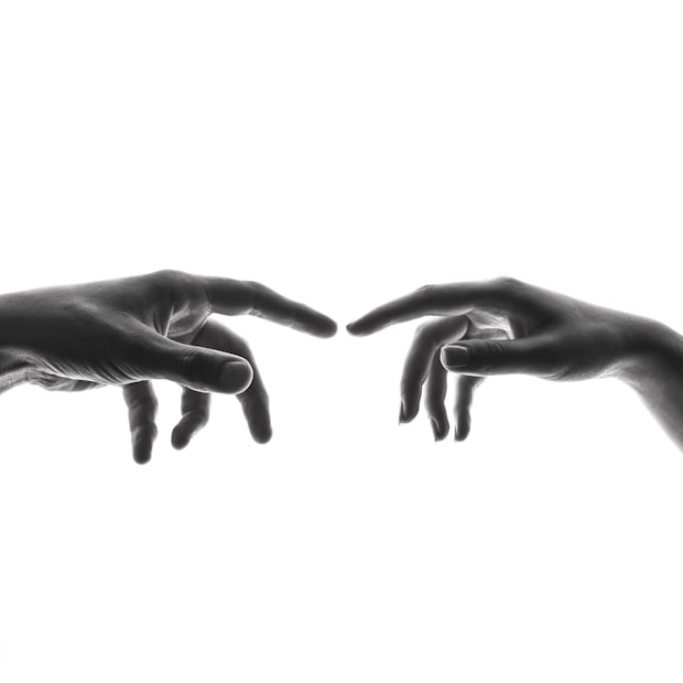 Two hands reaching toward each other against a white ground