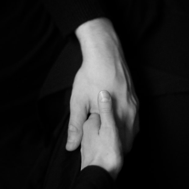 A single hand held against a dark background