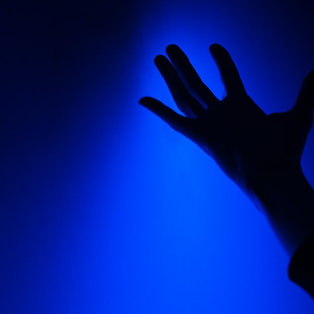 The shadow of a hand cast across a plain surface