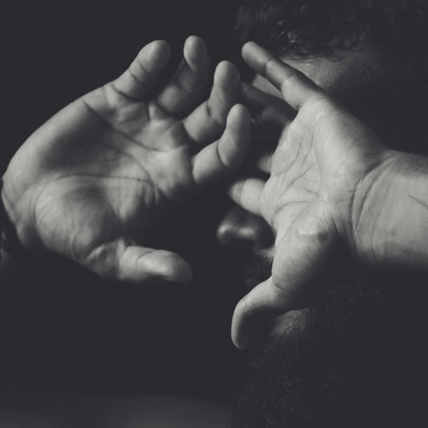Two hands opened toward the camera in strong side light