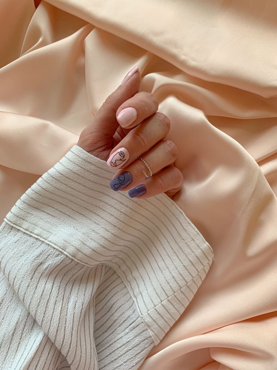 A hand with soft lilac and cream nails resting against a cream knitted sleeve