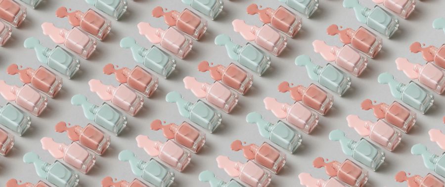A repeating pattern of pastel pink and mint nail polish bottles